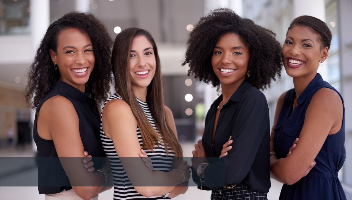 four women smiling while looking at the camera 